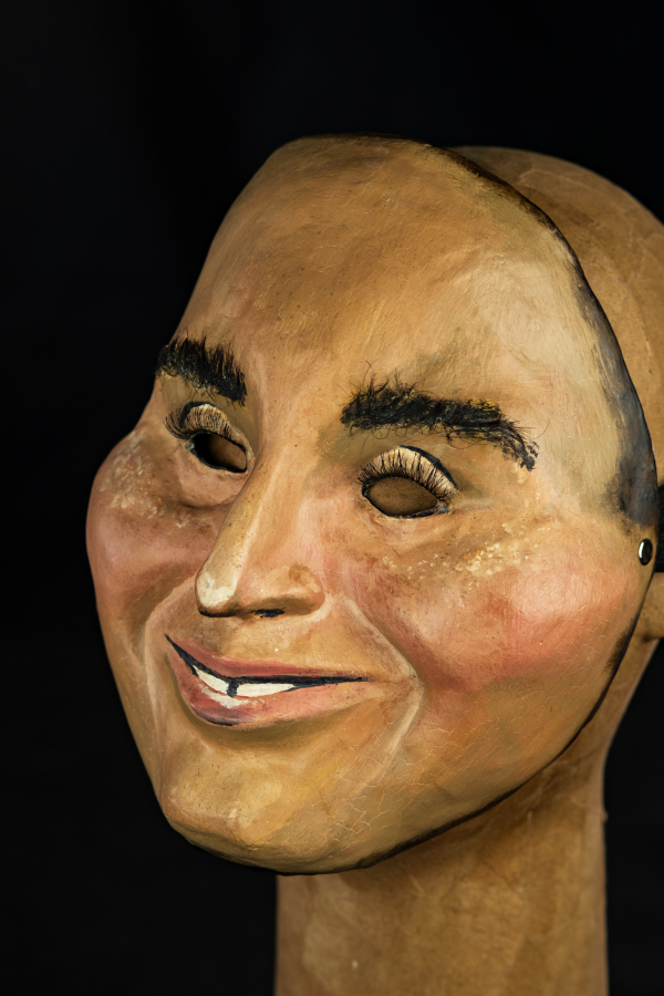 Na foto, um rosto sorridente de pele clara com um nariz comprido e bochechas grandes de uma criança. Os dentes divididos e um olhar sapeca tem os olhos pequenos e cílios compridos. Há também vermelhidão nas bochechas e sardas que se aproximam dos olhos. Tem a forma simétrica e aspecto de jovialidade.