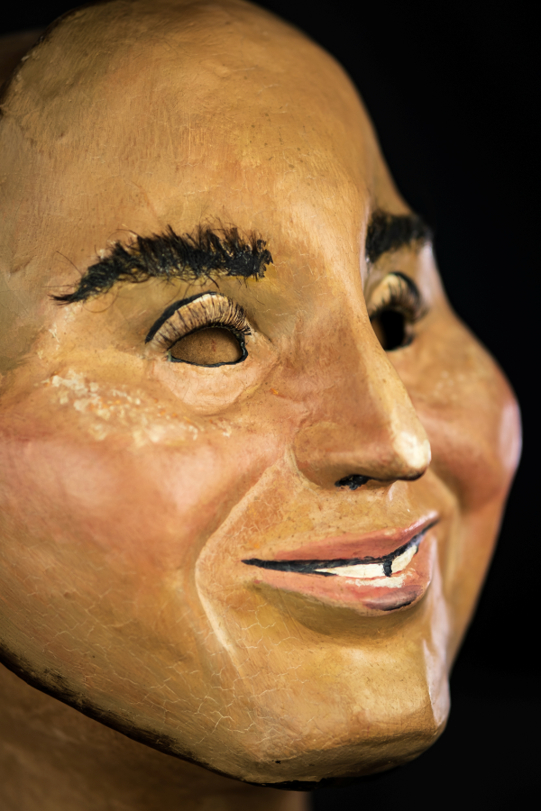 Na foto, um rosto sorridente de pele clara com um nariz comprido e bochechas grandes de uma criança. Os dentes divididos e um olhar sapeca tem os olhos pequenos e cílios compridos. Há também vermelhidão nas bochechas e sardas que se aproximam dos olhos. Tem a forma simétrica e aspecto de jovialidade.